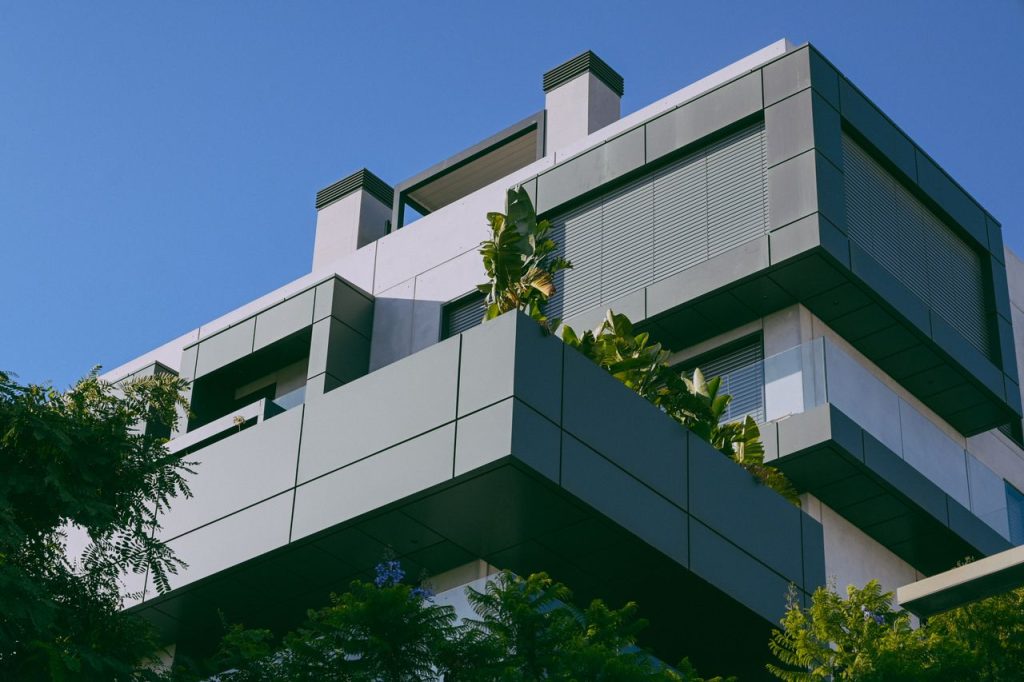 Contemporary building design featuring sleek lines and integrated greenery against a clear blue sky.